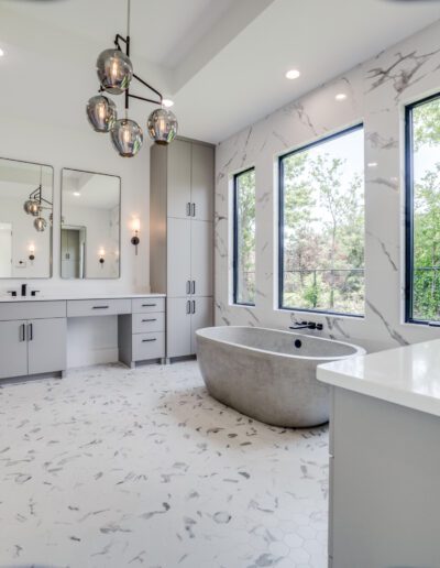 Modern bathroom with a freestanding tub, double vanity, and marble finishes.