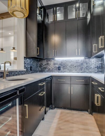 Modern kitchen interior with black cabinetry and stainless steel appliances.
